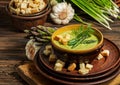 Purred creamy asparagus soup in glass bowl on black plate against raw fresh asparagus and greenery Royalty Free Stock Photo