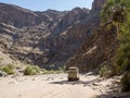Purros, Namibia - July 26, 2015: 4x4 offroad vehicle driving in dry river bed of Hoarusib River with mountains