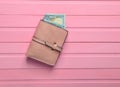 A purse with dollar bills on a pink wooden table. Top view Royalty Free Stock Photo