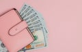 Purse with one hundred dollars banknotes on pink background. Flat lay, top view, copy space Royalty Free Stock Photo