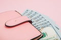 Purse with one hundred dollars banknotes on pink background. Flat lay, top view, copy space Royalty Free Stock Photo