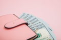 Purse with one hundred dollars banknotes on pink background. Flat lay, top view, copy space Royalty Free Stock Photo