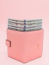 Purse with one hundred dollars banknotes on pink background. Flat lay, top view, copy space Royalty Free Stock Photo