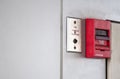 Push button switch, fire alarm on grey wall for alarm and security system with fire extinguisher port Royalty Free Stock Photo