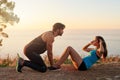 We push each other through every workout. a young man motivating his girlfriend while shes doing sit ups.