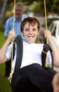 Push me higher dad. Young boy being pushed on a tyre swing by his father in the backyard. Royalty Free Stock Photo