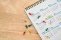 push pins with white yearly calendar on wooden table