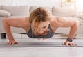 Push-ups at home. Strongly fitness woman doing exercises on mat