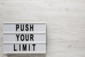 `Push your limit` words on a modern board on a white wooden background, top view. Overhead, from above, flat lay. Copy space