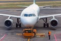 Pushback tractor is towing the aircraft to a parking lot, aviation marshall. Close up view