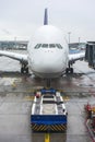 Pushback tug and a large airplane at an airport Royalty Free Stock Photo