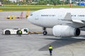 Pushing the airplane back the cart tow tracktor on the front landing gear of the chassis. Royalty Free Stock Photo