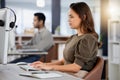 Pushing through the day. a young female call center agent using a computer at her desk. Royalty Free Stock Photo