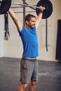 Pushing the limits. a handsome young man lifting weights while working out in the gym. Royalty Free Stock Photo