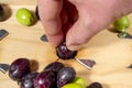 Pushing olives on a a traditional wooden slitter