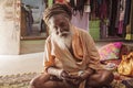 Sadhu sitting in the street market fashion shop interior