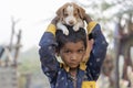 Indian poor child with small dog on time Pushkar Camel Mela, Rajasthan, India, close up portrait