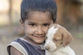 Indian poor child with small dog on time Pushkar Camel Mela, Rajasthan, India, close up portrait