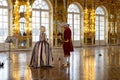 Museum workers in court costumes are waiting for visitors in the front hall with a golden finish