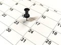 Pushpin stuck into calendar, event reminder