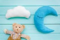 Baby care concept with moon pillow, clouds, teddy bear and toy for sleep of newborn on mint green background top view Royalty Free Stock Photo