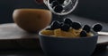 put fresh blueberries over thai mango in natural organic yogurt in blue bowl