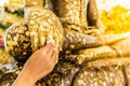 Put gold leaf onto The Buddha statue to gild.