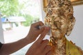 Put gold leaf ontothe Buddha image/statue