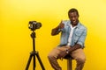 Put like for live blog. Portrait of happy friendly man smiling at his professional dslr camera and showing thumbs up. isolated on Royalty Free Stock Photo