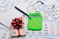 They put a wad of money in an envelope, rewound with a red ribbon and a bow, next to it lies a calculator, a pen, glasses and a Royalty Free Stock Photo