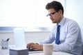 Put in the work and success will follow. a handsome young businessman working on a laptop.