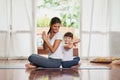 Put your hands together. a cheerful young mother and daughter doing a yoga pose together while being seated against each Royalty Free Stock Photo