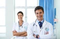 Put your life in their hands. Portrait of a handsome young doctor with his nursing assistant in the background. Royalty Free Stock Photo