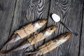 Putassu Cold smoked. The fish is wrapped with a strip of paper. Tied with linen twine. Lies on pine boards. Teaspoon with salt. Royalty Free Stock Photo