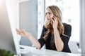 She puts passion into her profession. a young businesswoman using a mobile phone and computer at her desk in a modern Royalty Free Stock Photo