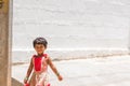 PUTTAPARTHI, ANDHRA PRADESH, INDIA - JULY 9, 2017: Happy indian girl playing on the street. Copy space for text.