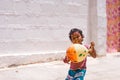 PUTTAPARTHI, ANDHRA PRADESH, INDIA - JULY 9, 2017: Happy indian girl playing on the street. Copy space for text.