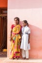 PUTTAPARTHI, ANDHRA PRADESH, INDIA - JULY 9, 2017: Indian woman in sari and girl in school uniform. Copy space for text. Vertical.