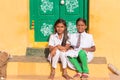 PUTTAPARTHI, ANDHRA PRADESH, INDIA - JULY 9, 2017: Two cute Indian girl sitting on the doorstep. Copy space for text.