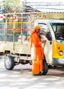 PUTTAPARTHI, INDIA - NOVEMBER 29, 2018: Indian man in orange clothes stands near a car.