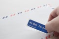 Putting air mail tag on envelope Royalty Free Stock Photo