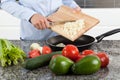 Putting chopped onion in the pan Royalty Free Stock Photo