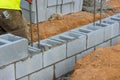 Putting down the second row of cement blocks by a bricklayer construction worker