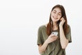 Putting earphones in ears and rest of world can wait. Portrait of pleased relaxed attractive dreamy girl with brown hair