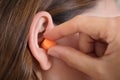 Putting Earplug Into Her Ear Royalty Free Stock Photo