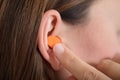 Putting Earplug Into Her Ear Royalty Free Stock Photo