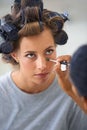 Putting on the final touches. A beautiful young woman spending the day getting her hair and makeup done. Royalty Free Stock Photo