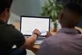 Putting the focus on finance. two young businessmen using a laptop with graphs on the screen during a meeting in a Royalty Free Stock Photo