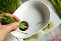 Putting fresh green barley grass into a juicer to prepare homemade juice Royalty Free Stock Photo