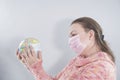 Putting a green surgical face mask on the globe sphere model. Heal the world from coronavirus covid-19 concept